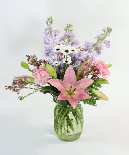 Fresh spring flowers in a cute mason jar vase. This bouquet of fragrant stock, Asiatic lilies, carnations and more is perfect to brighten someone's day!