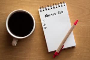 Bucket list with red pen and coffee