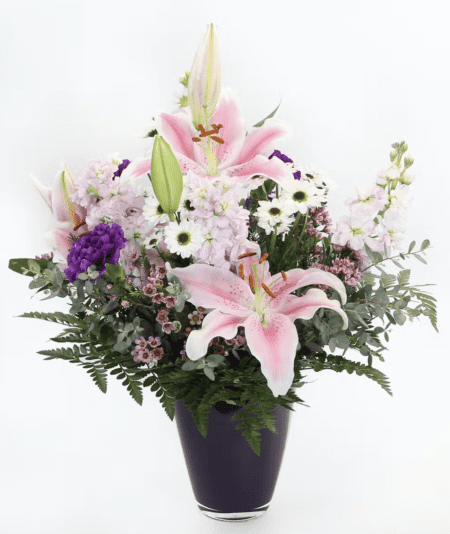 This soft fragrant design features Oriental lilies, stock, purple carnations and more in a purple vase.