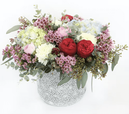 Low and lush, this luxury bouquet features garden roses, hydrangea, ranunculus and accents in a textured vase.